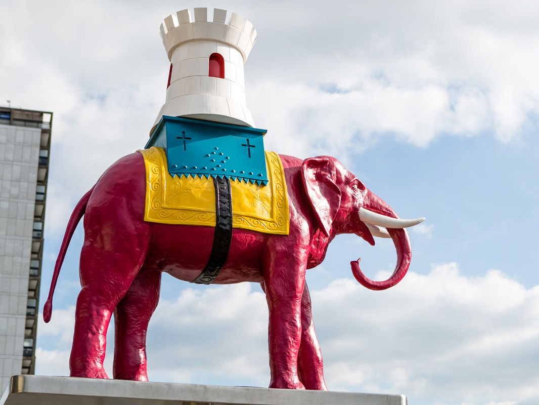 Pink elephant state with sky and clouds in background, outside Elephant and Castle station