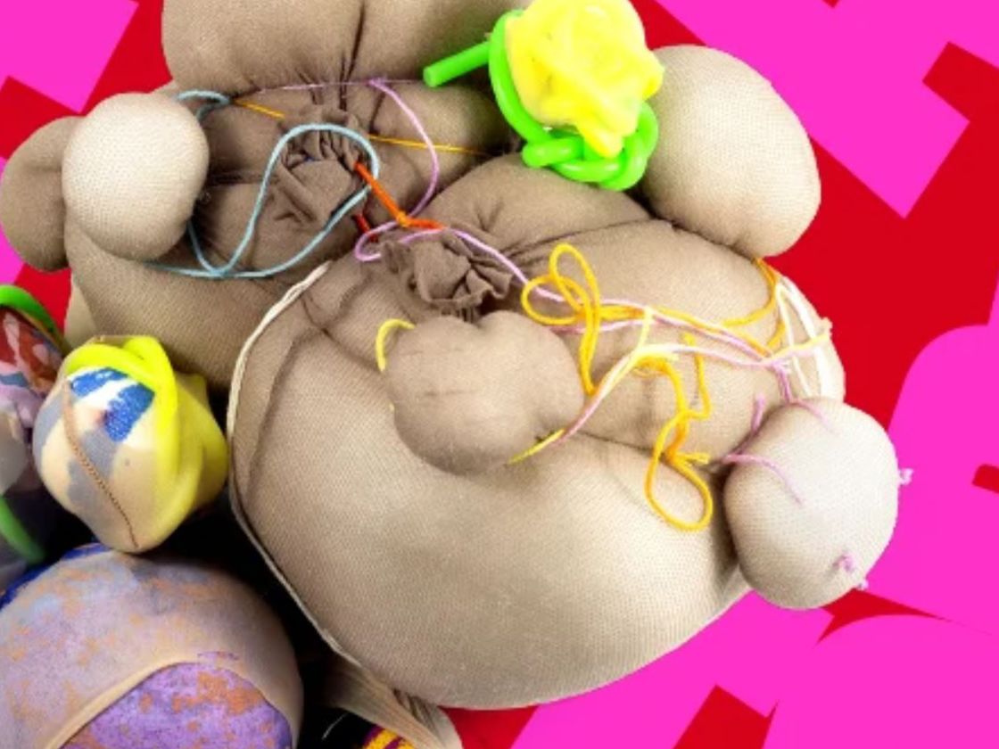 Break factor logo in pink and red in background with a piece of textile art in front