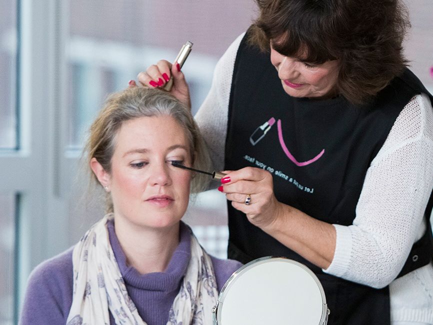 Three women doing their makeup