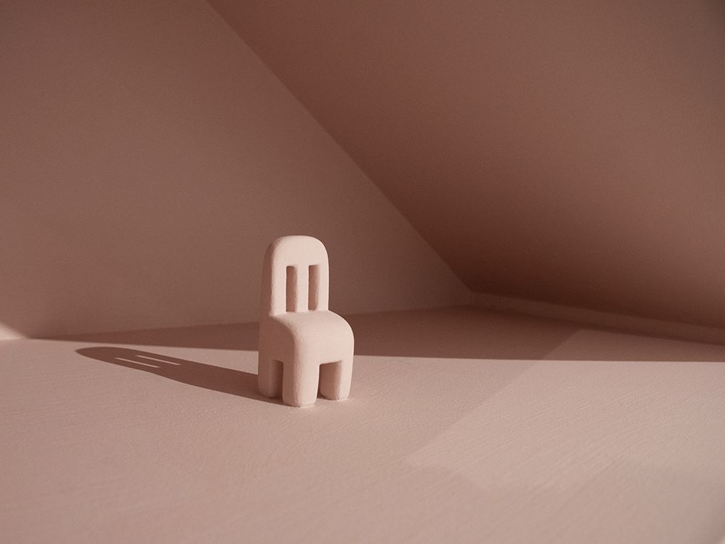 A small sculpture of a pink chair.