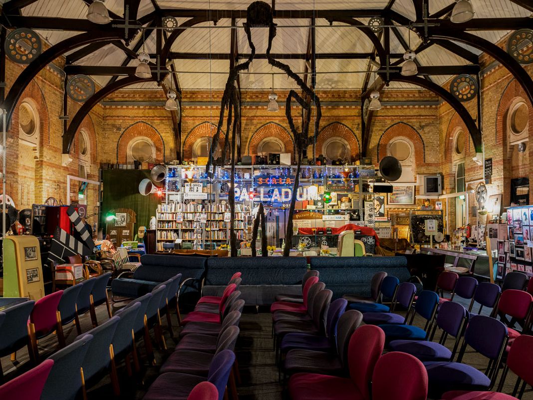 Rows of seats in front of bare brick walls of The Cinema Museum