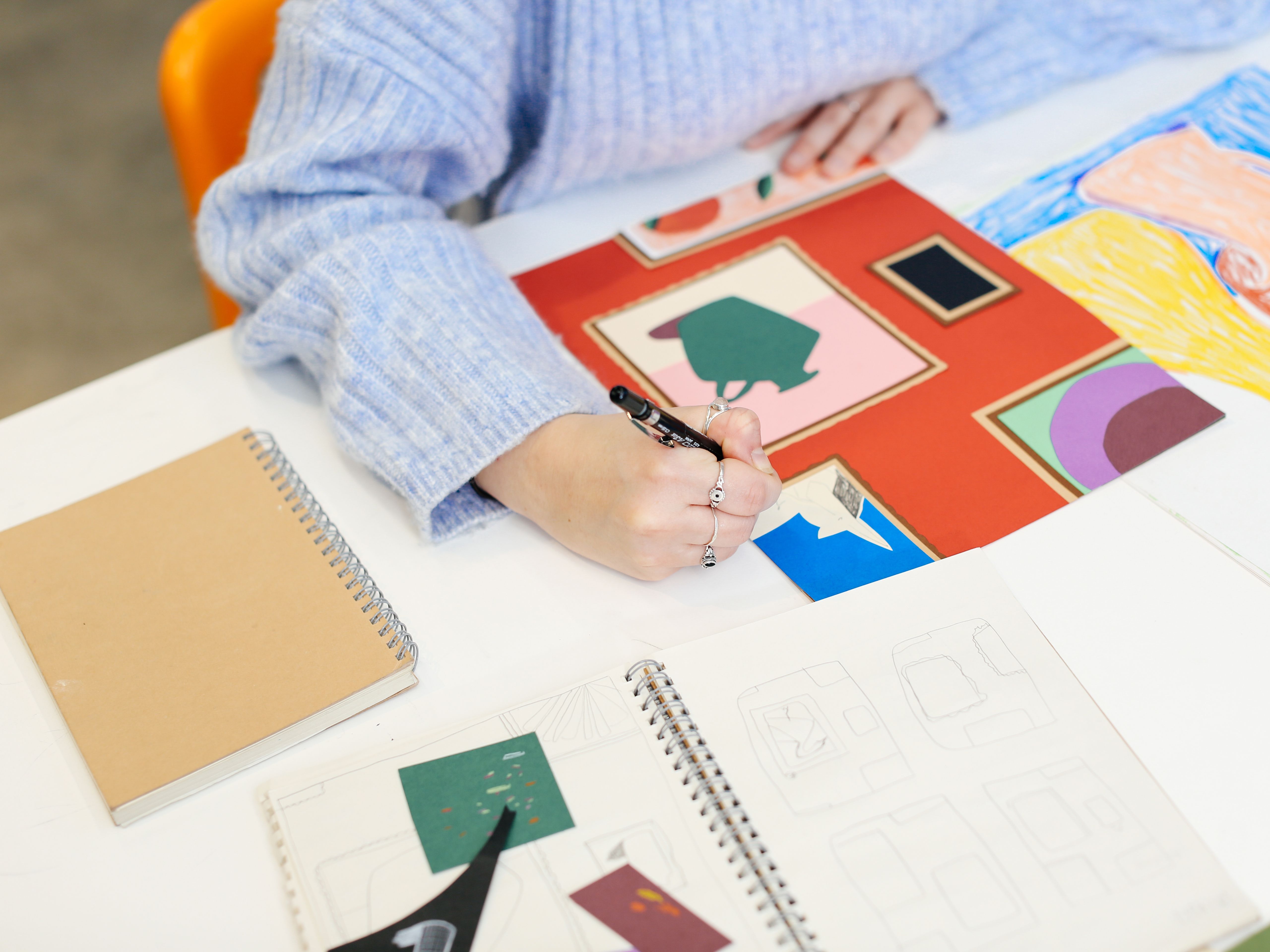 A student drawing in a sketchbook 