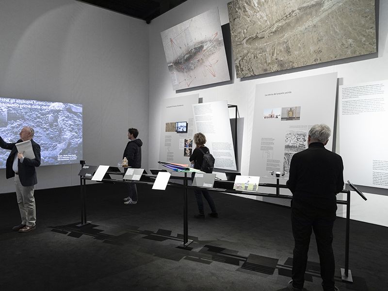 Photo of Maps of Defiance exhibition with visitors and panels. 