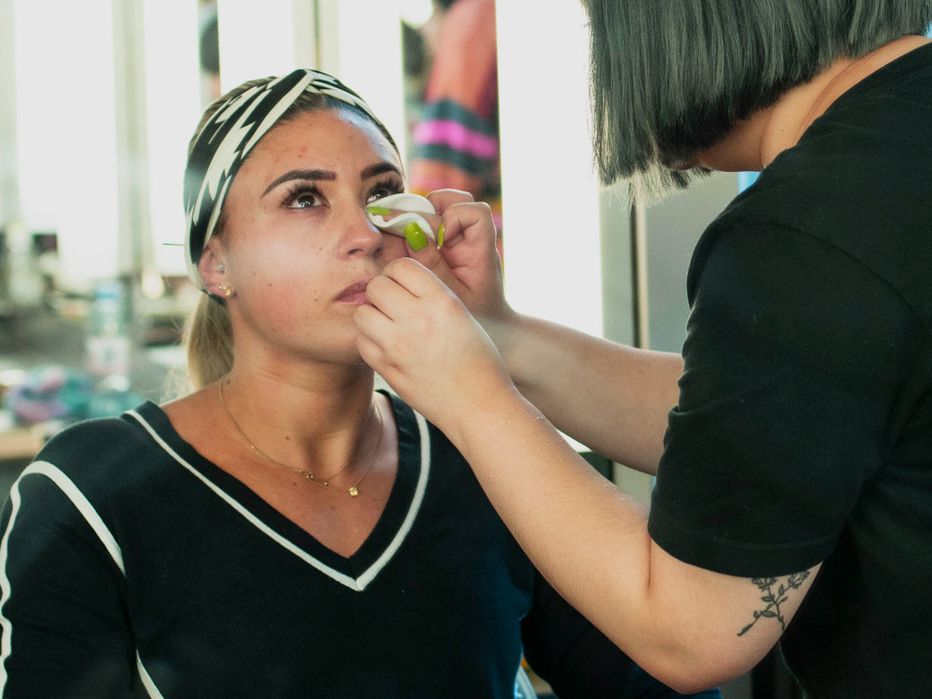 Student applying make up to another student