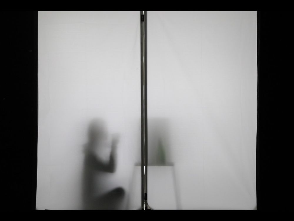 Silhouette of person sat at desk.