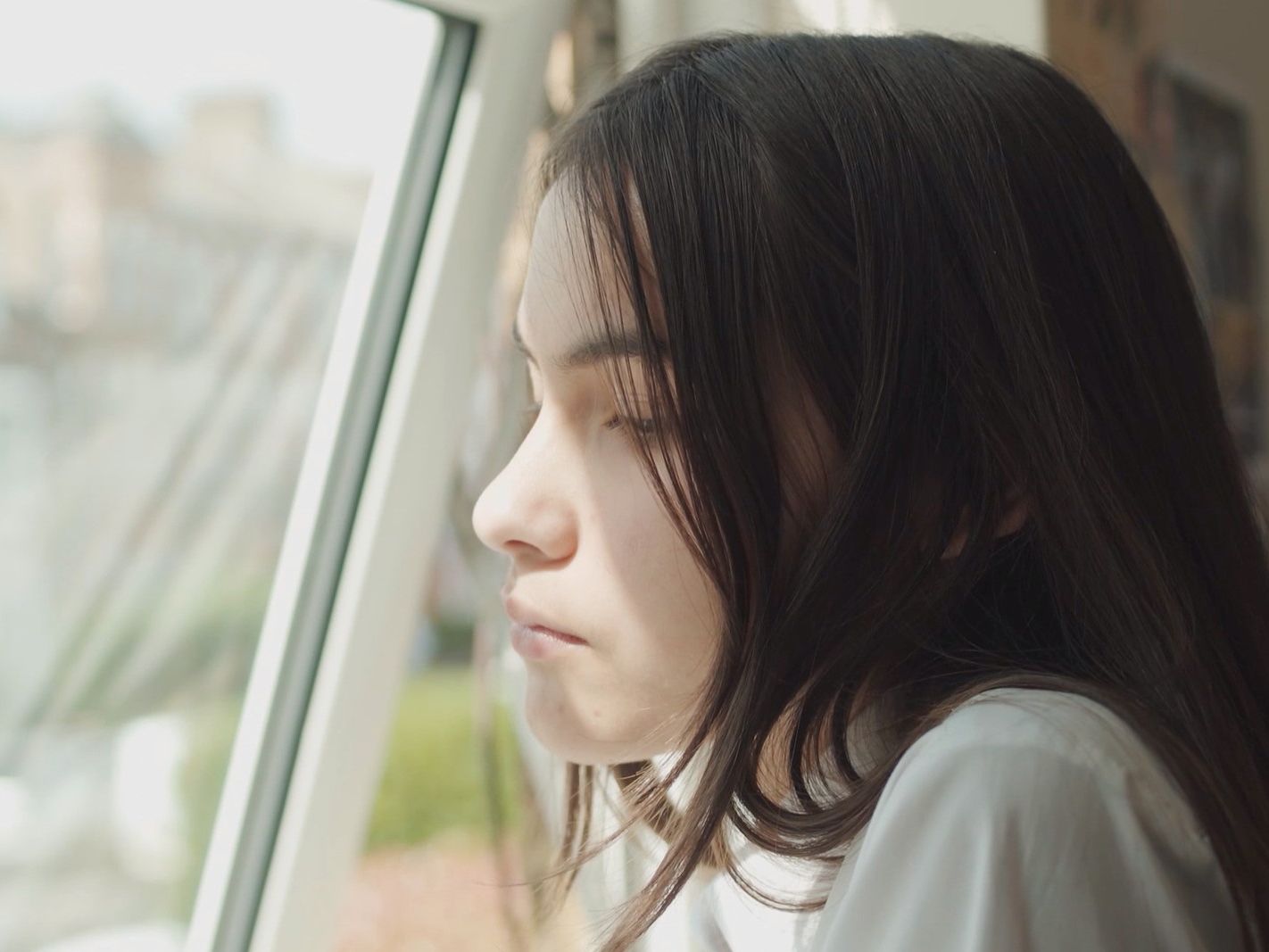 A young girl stares out of the window.