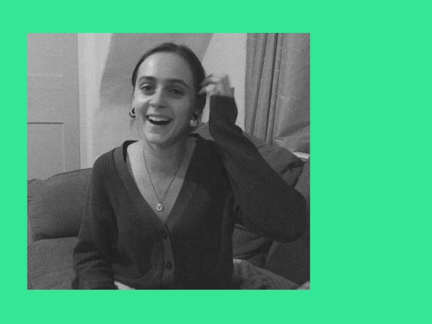 A black and white portrait of a smiling woman.