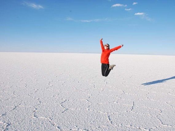 An-Sophie leaping in the air in joy, photographed on ice in what looks like a glacer