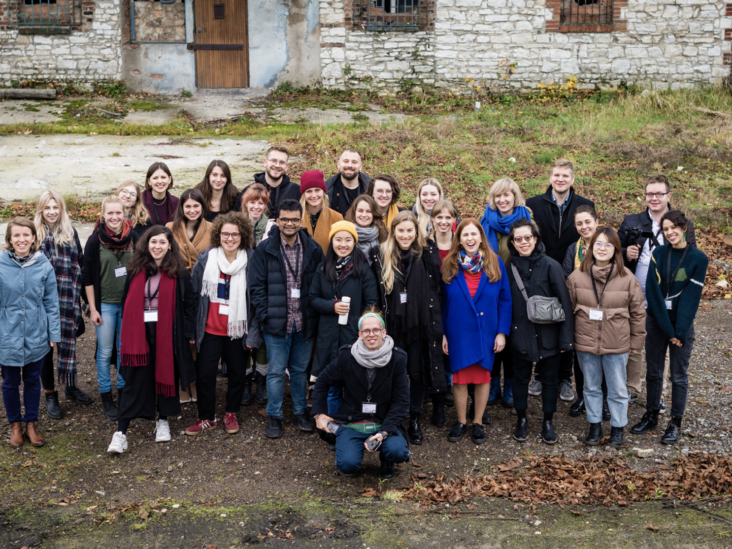 Group photo of students and academics in front of an old building