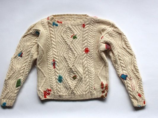 A beige/white woolen jumper with colourful splodges all over