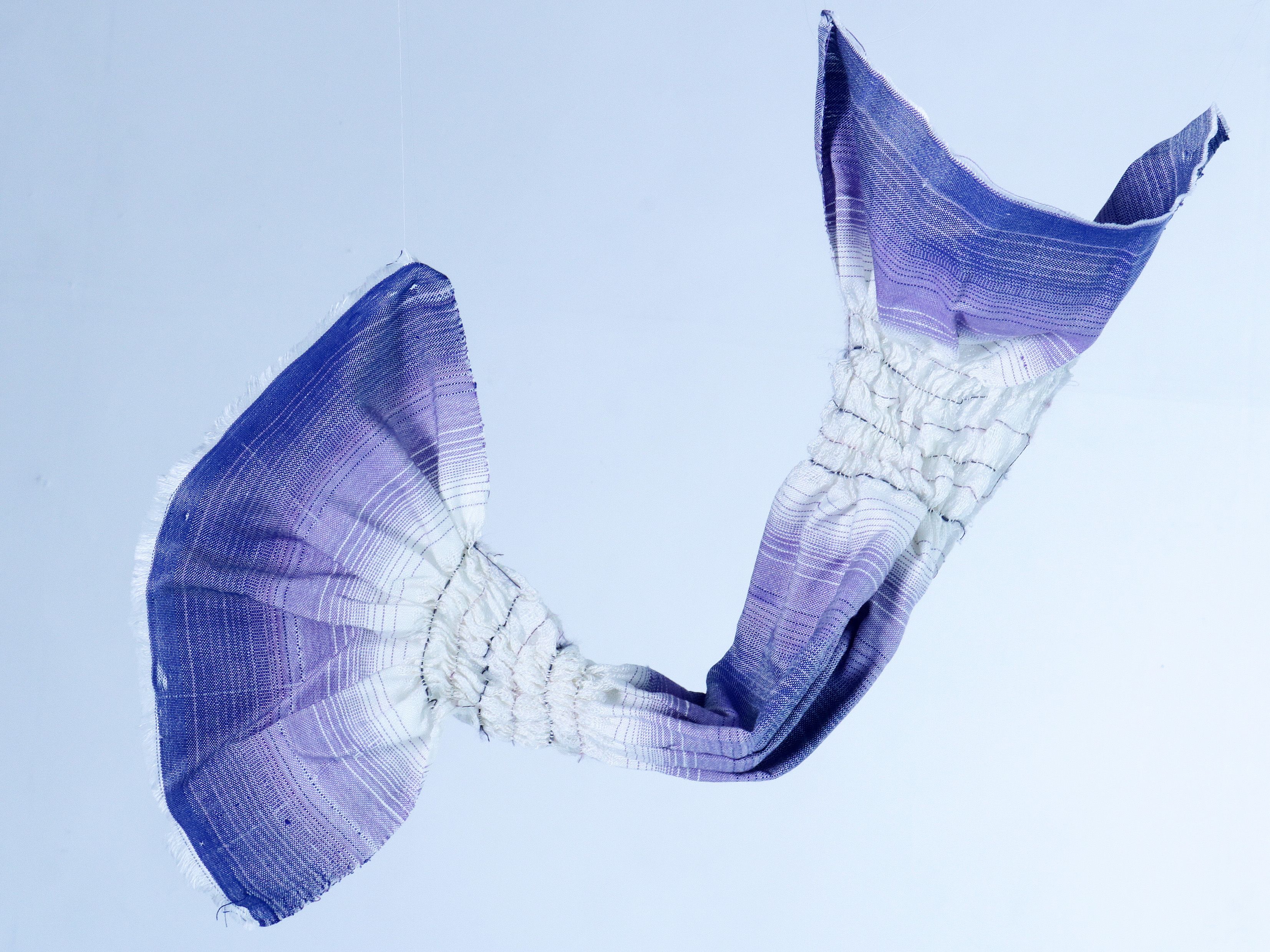 Picture of a violet and white fabric hanging in the air