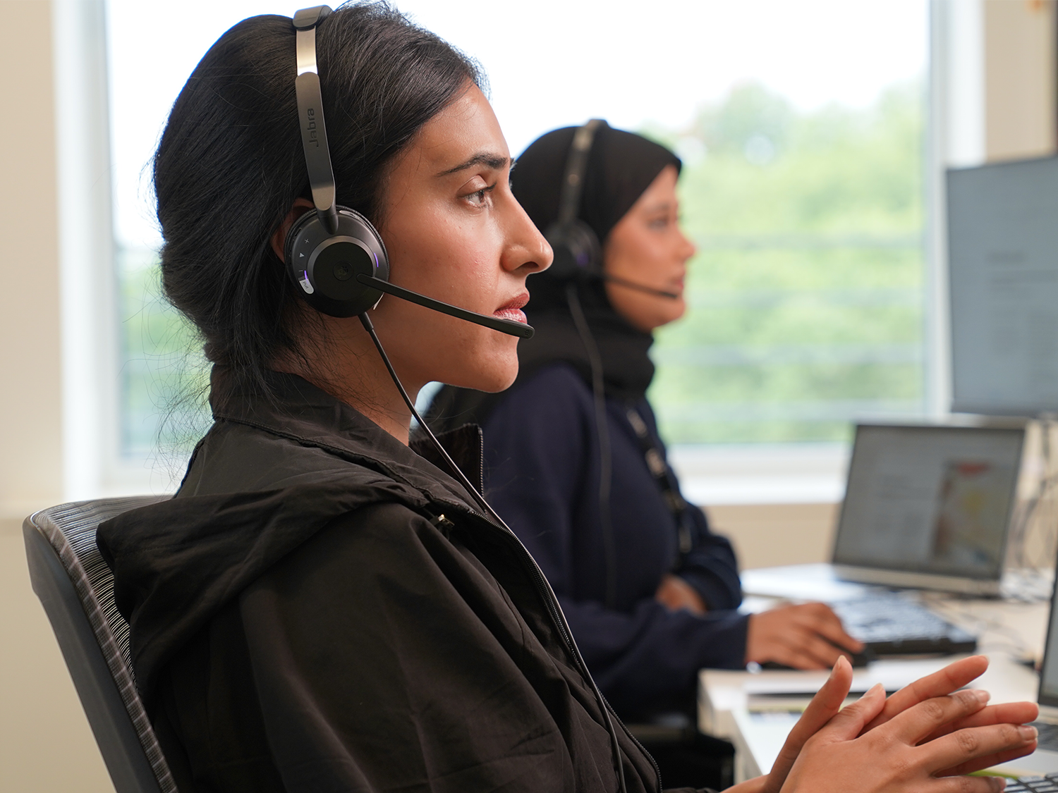 woman at work with head set on in an office setting