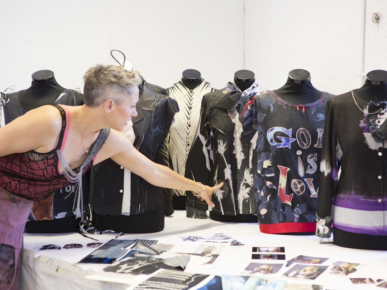 Rebecca Earley in a workshop working with shirts on mannequins and images laid out on a table