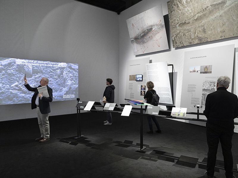 Photo of Maps of Defiance exhibition with visitors and panels. 