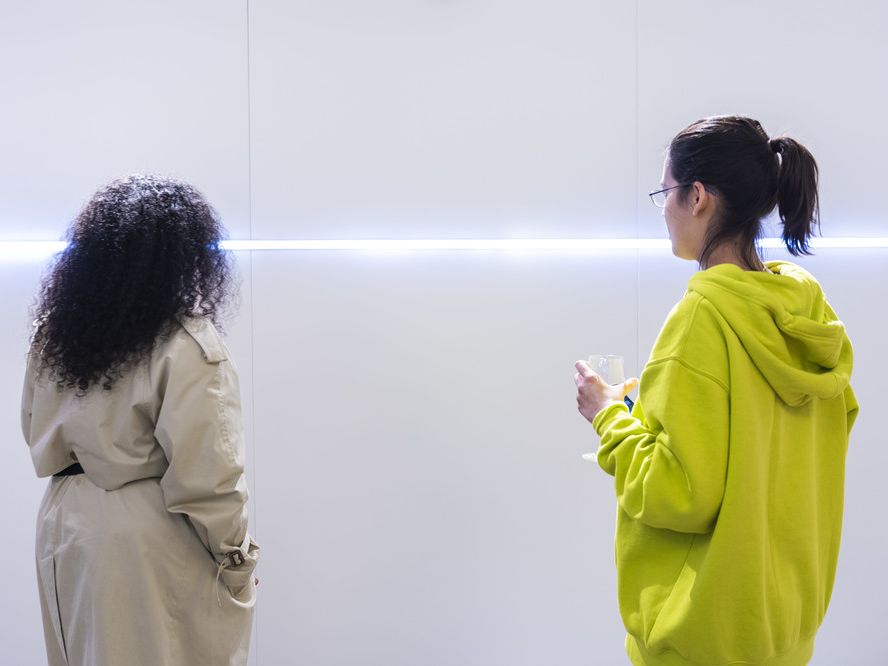 Two young women in front of a white light installaion 