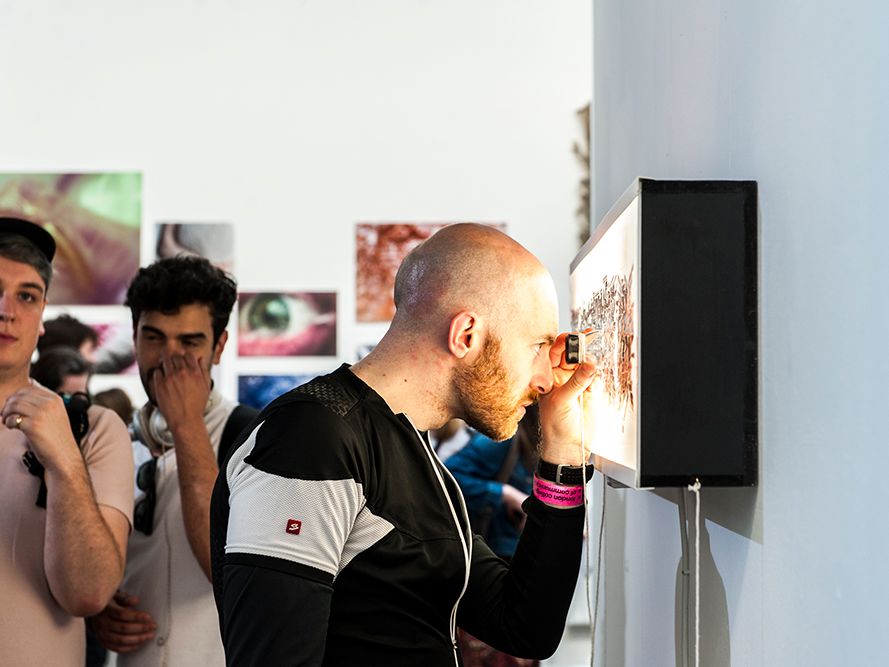 Image of a person viewing a photographic print up close at an exhibition
