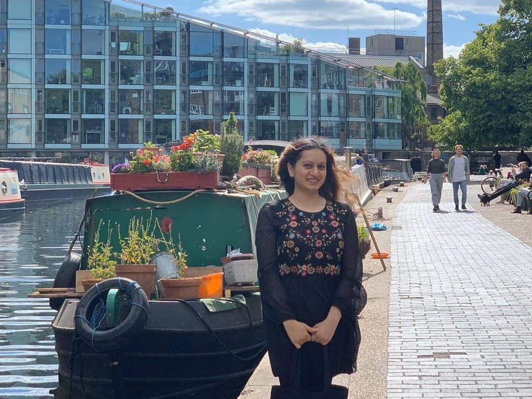 Zonaira stands in front of a canal boat on a sunny day