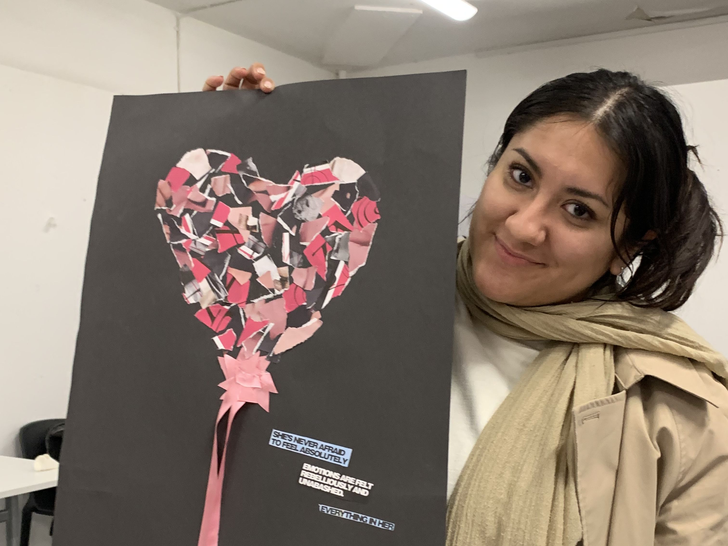 a student holding up a collage of a heart