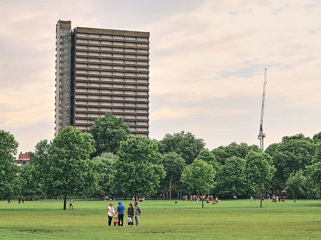 Photograph of a park and large tower block.