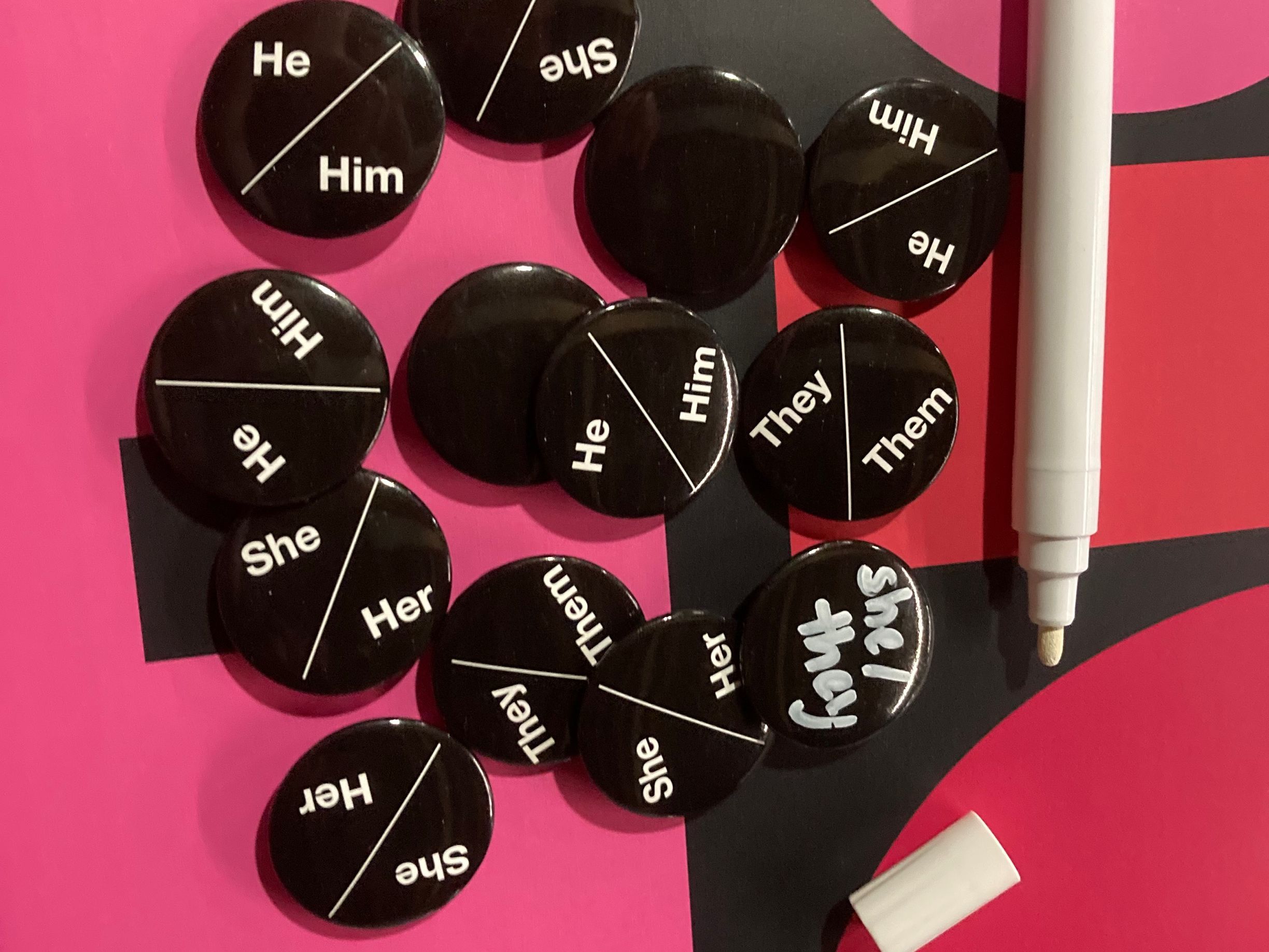 Pronoun badges are scattered across a table.