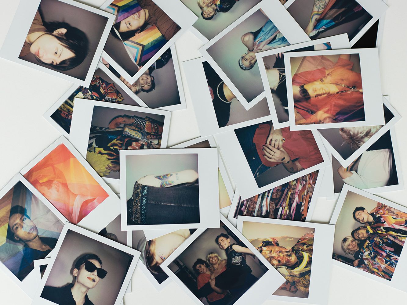 Colourful Polaroid images scattered across white table