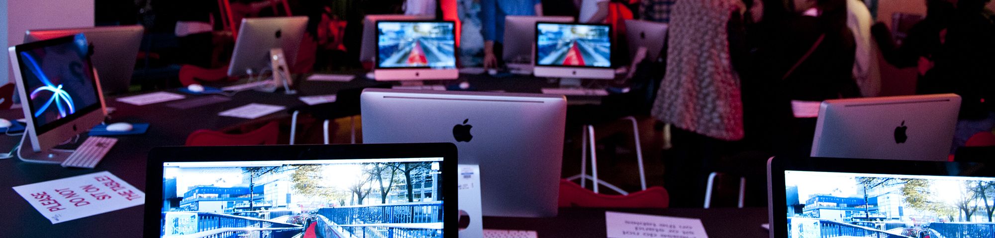 A room with various computer screens showing colourful images