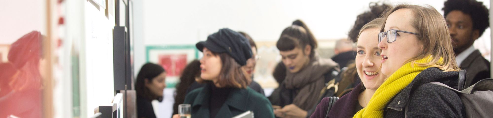 crowd of people looking at framed artworks on the walk of the Lethaby Gallery
