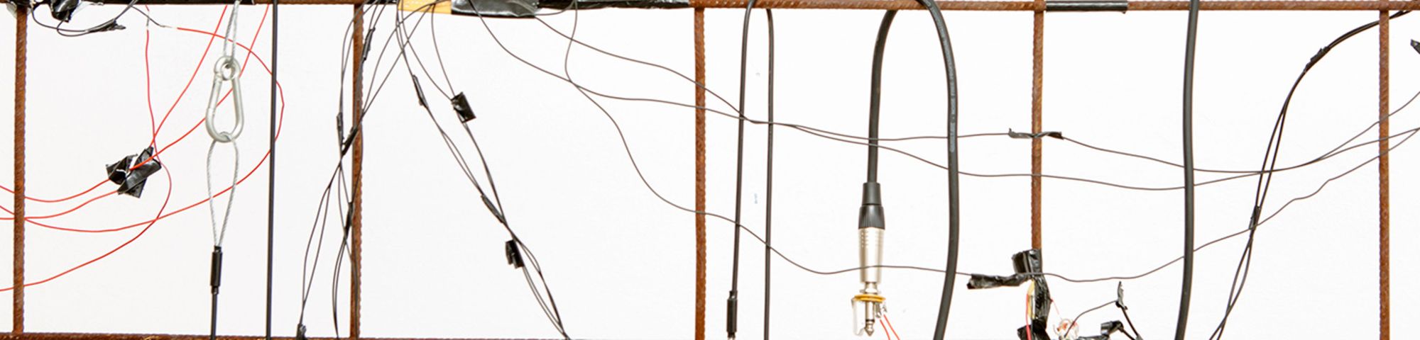 Image of electrical wires, ropes and lights hanging on a metal frame