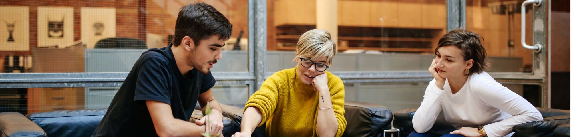 Two students sit in an office and look through work.