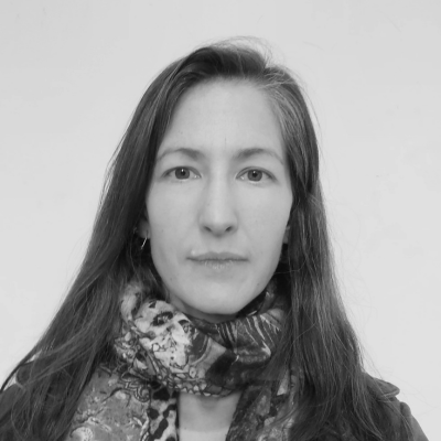 Rhosyn Tuta, Senior R&D Fellow in Cultural Anthropology, she has long dark hair and is wearing a patterned scarf. 