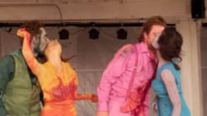Photo of two couples on stage, one couple are kissing