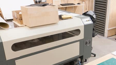A large machine which has a wooden box on top of it