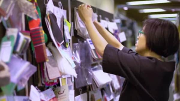 A woman looking at materials hung on a wall