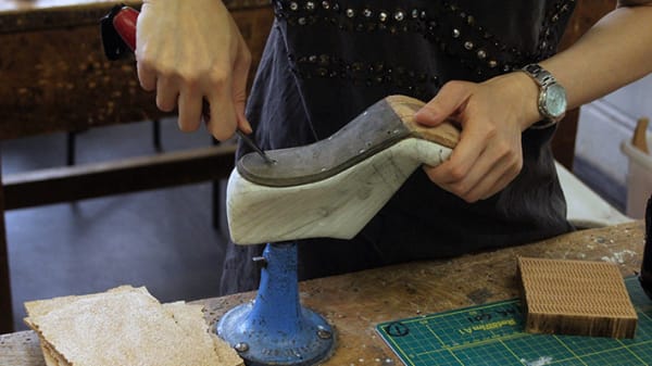 Person carving the sole of a shoe
