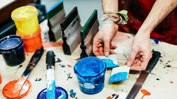 Hands using paint pots and brushes