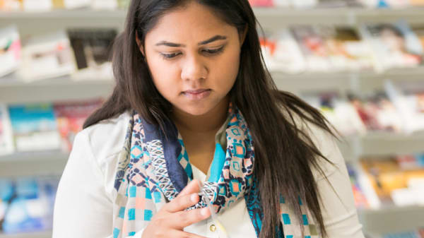 Student in scarf making hand movements in the library