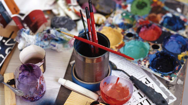 Photo of tins with paint brushes in a paint palettes
