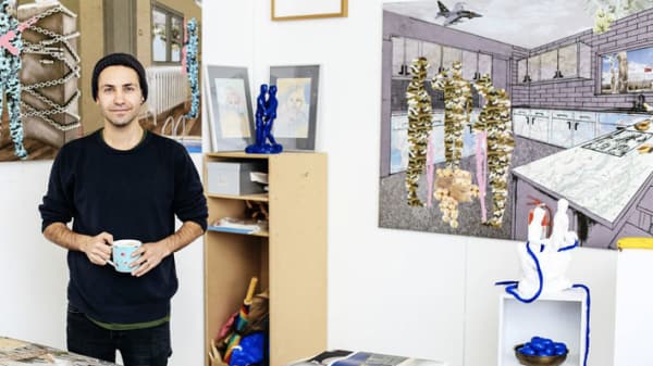 Male student standing in front of painting