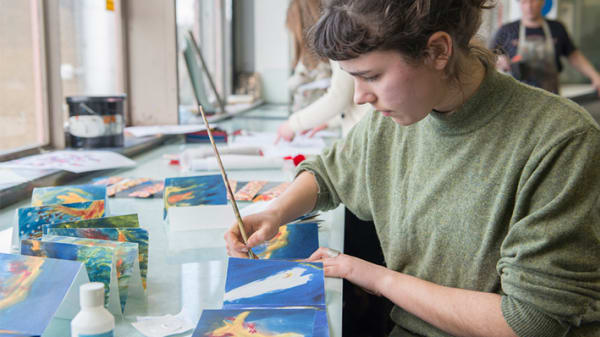 Photo of woman wearing a green jumper painting