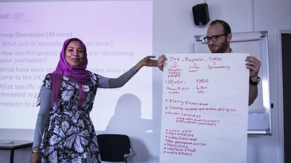 Two people involved in LCC's Refugee Journalism Project give a presentation.