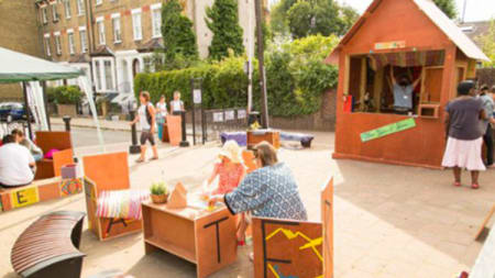 An outdoor area with a play shed and seating