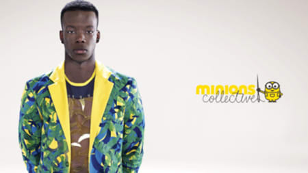A man wearing a brightly coloured green and yellow jacket stood next to the Minions logo