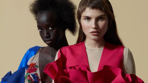 Two female models wearing MA Fashion Design Technology Womenswear 2018 clothing against a putty coloured background.