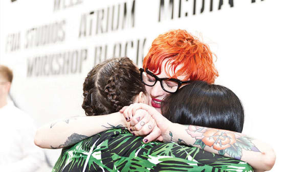 Photo of a woman hugging to people