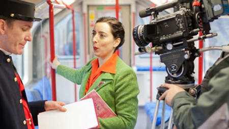 A woman being filmed on a tube carriage