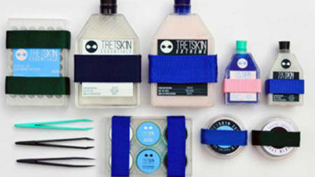 A flat lay of different pastel coloured bottles, tweezers and capsules.