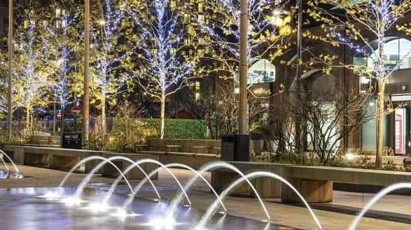 A row of fountains next to a row of benches