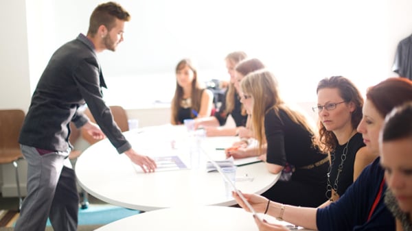 Photo of a man standing in front of a table of women