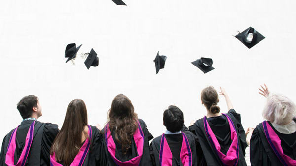 Students throwing mortar boards in the air