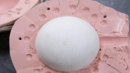 Close up image of a pink and wide oval 3D object